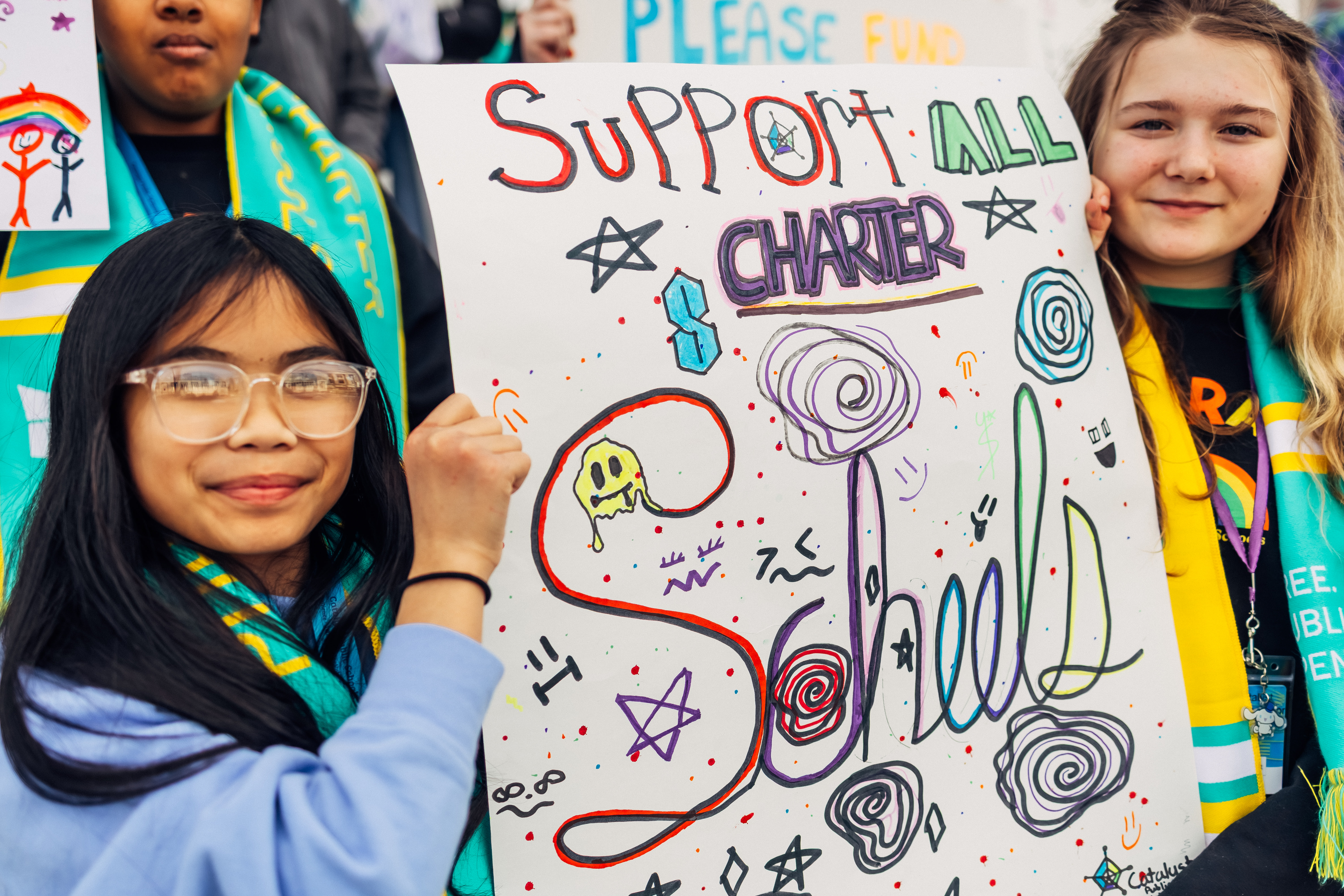 Students holding a sign that says "Support all charter schools"